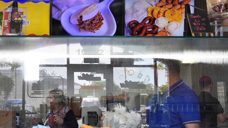 ARCHIVO - Empleados trabajan en una franquicia de "Sabor Venezolano", uno de los 18 negocios...