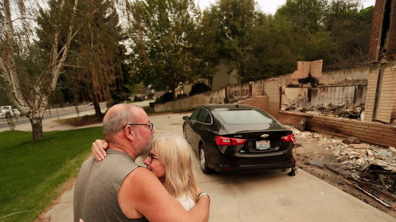Allen Sather y su esposa Kimberley se abrazan ante la vivienda que arriendan en W. Indian...