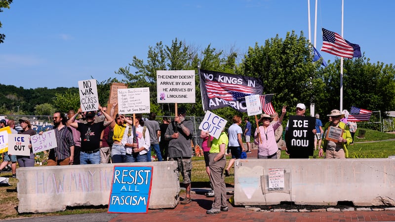 Varias personas sostienen pancartas en señal de protesta durante una vigilia en memoria de...