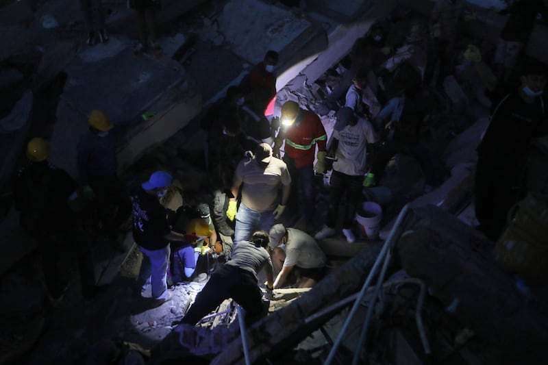 Personas buscan entre los escombros tras el terremoto que azotó Cali, Colombia, el lunes 10 de...