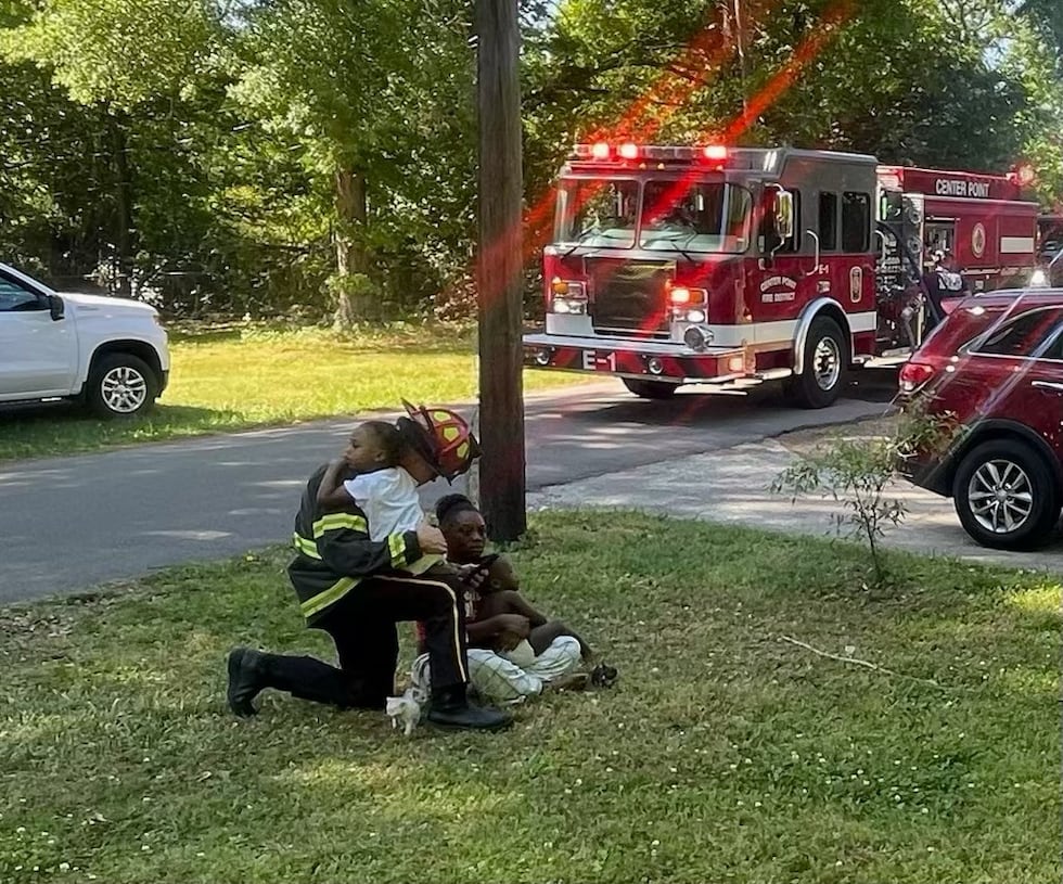 El subjefe de bomberos de Center Point consuela a unos niños.