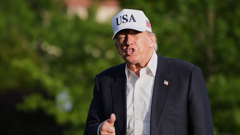 President Donald Trump gestures to reporters as he walks across the South Lawn of the White...