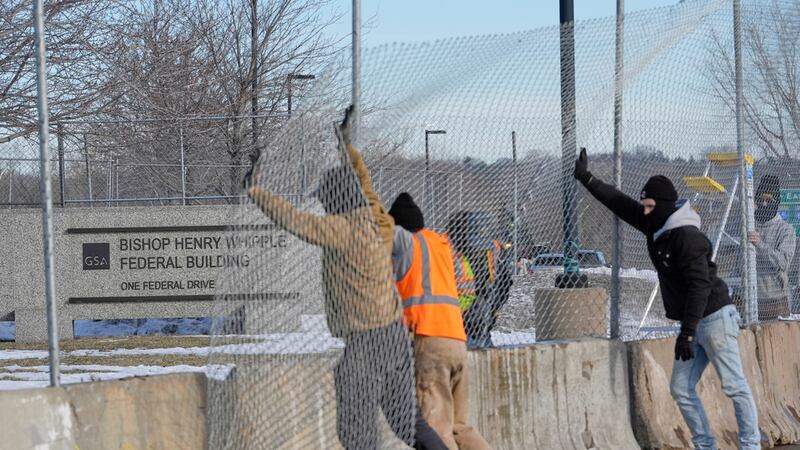 Obreros erigen una cerca en torno al Bishop Whipple Federal Building en Minneapolis el 12 de...