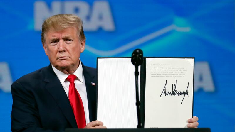 ARCHIVO - El presidente de Estados Unidos, Donald Trump, sostiene un documento con su firma...