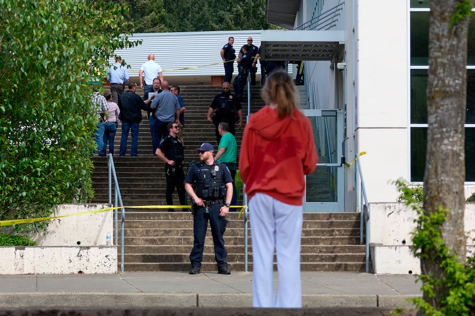 Un estudiante observa a agentes de la Policía de Tacoma luego de que varias personas...