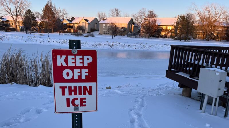 "Keep off: Thin Ice" Written on a sign in front of a frozen body of water.
