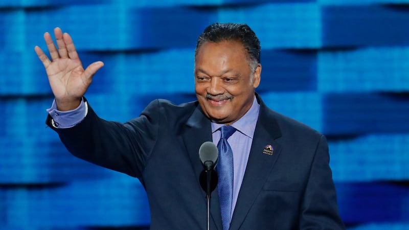 ARCHIVO - El reverendo Jesse Jackson saluda mientras sube al estrado en el tercer día de la...