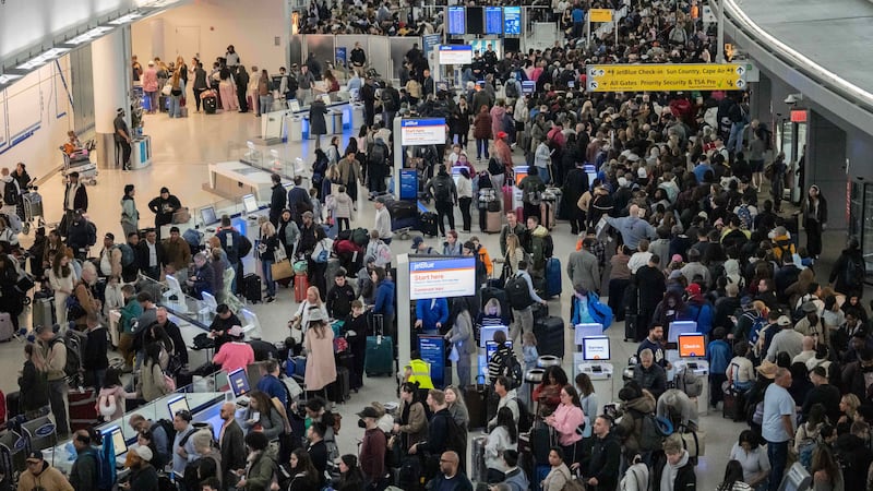 People wait in a TSA line at the John F. Kennedy International Airport, Sunday, March 22,...