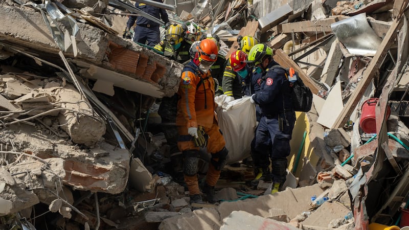 ARCHIVO | Rescuers carry the body of a victim from the rubble four days after after an...