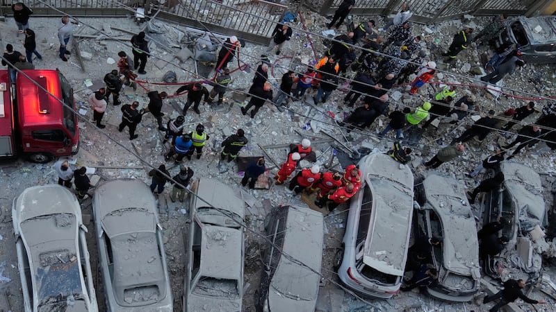 Rescatistas trabajan en el lugar donde ataques israelíes alcanzaron departamentos en Beirut,...
